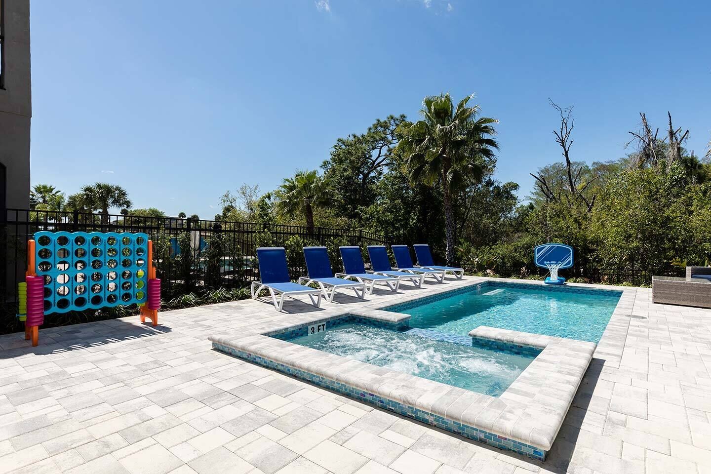 A swimming pool with lounge chairs, a water slide, and a children's play area.