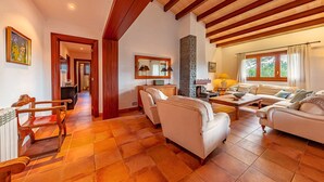 A spacious living room with a high ceiling and wooden beams, featuring a sofa set, a coffee table, and a fireplace. - Villa Marc, 4 bedrooms, private swimming pool, BBQ, Pollensa (Pollensa)
