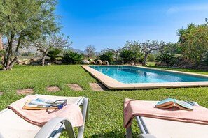 Relax by the serene pool surrounded by lush greenery and majestic mountains.