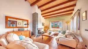A spacious living room with a fireplace, wooden beams, and a large mirror. - Villa Marc, 4 bedrooms, private swimming pool, BBQ, Pollensa (Pollensa)