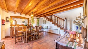 Un comedor espacioso con muebles de madera y una escalera que conduce a un nivel superior.