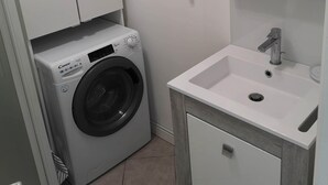 A compact bathroom with a washing machine, a sink, and a mirror. - Superb apartment with port and sea view, large balcony, quiet, free parking, wifi (bandol)