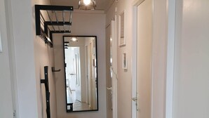 A hallway with a black bench, a large mirror, and a door. - Superb apartment with port and sea view, large balcony, quiet, free parking, wifi (bandol)