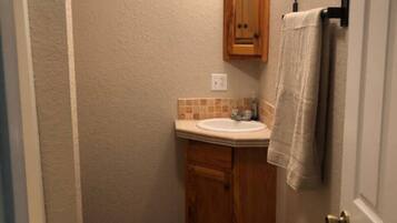Une petite salle de bain avec un meuble-lavabo en bois, un évier et un miroir.