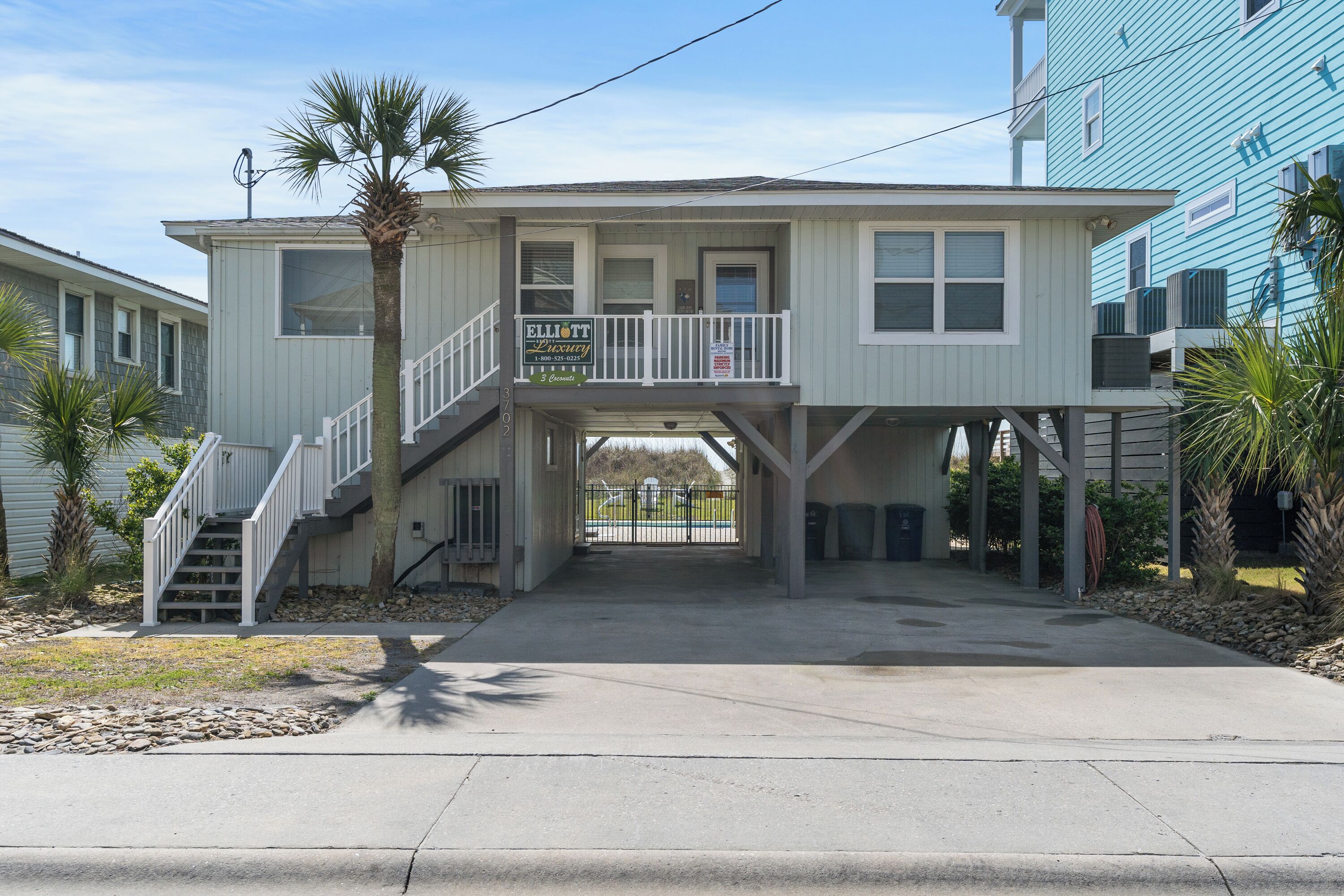 A two-story building with a balcony, a staircase, and a gated entrance.