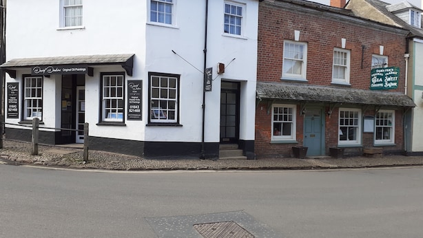 A traditional white building with a black trim, featuring a sign for 'Dun's Paintings' and 'Tea Sweet Shoppe Bazaar'. - House in Historic Village - Sleeps 6 (Minehead)