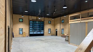 Un'ampia area interna caratterizzata da pareti in legno, un'ampia finestra e una ventola a soffitto.