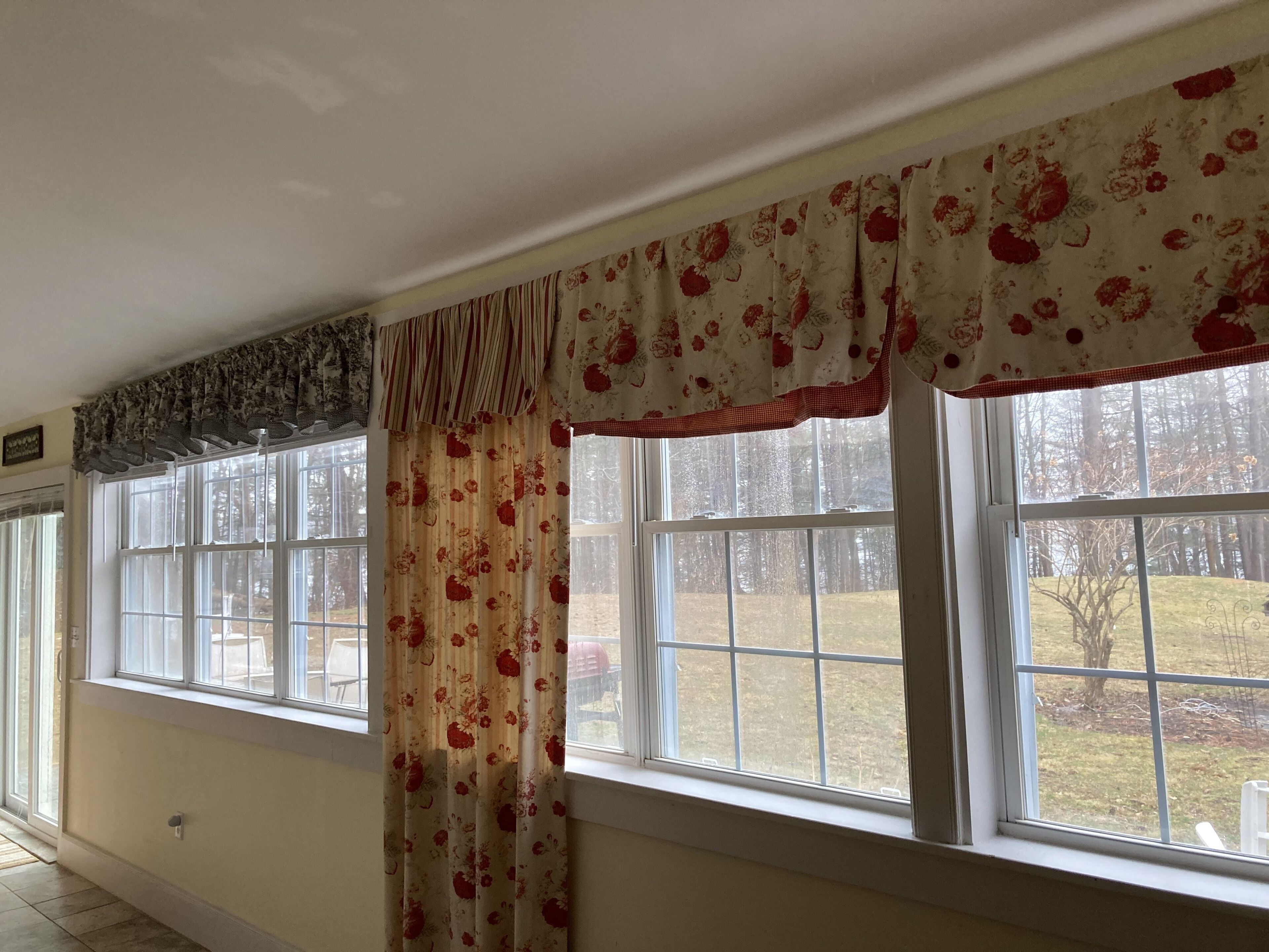 A room with large windows, a view of a yard, and a door with a lock.