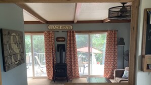 L'intérieur d'une maison de plage, avec une enseigne indiquant « MAISON DE PLAGE », un plafond en bois, un mur bleu et une vue sur l'extérieur.