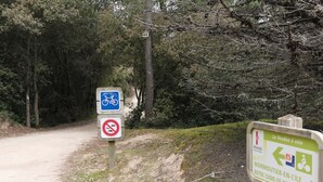 A dirt path with signs indicating a bicycle route and a no vehicle zone.