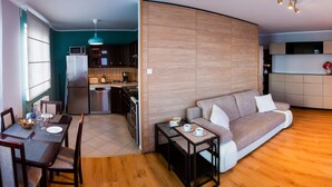 Un salon moderne comprenant un canapé, une table à manger et un coin cuisine.