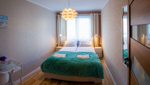 Une chambre à coucher avec un lit, des lampes de chevet, un bureau et une chaise.