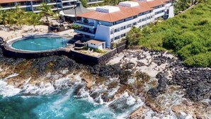 Un hôtel doté d’une piscine, d’une plage et d’un terrain rocheux.