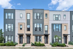 A modern multi-story residential building with a uniform facade, featuring rectangular windows and doors, and a flat roof.