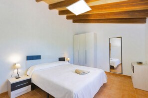 A bedroom with a bed, bedside tables, a wardrobe, a mirror, and a ceiling light fixture. - 219 Villa Ca Na Capitana ETV/9534 by Mallorca Char (Ariany)