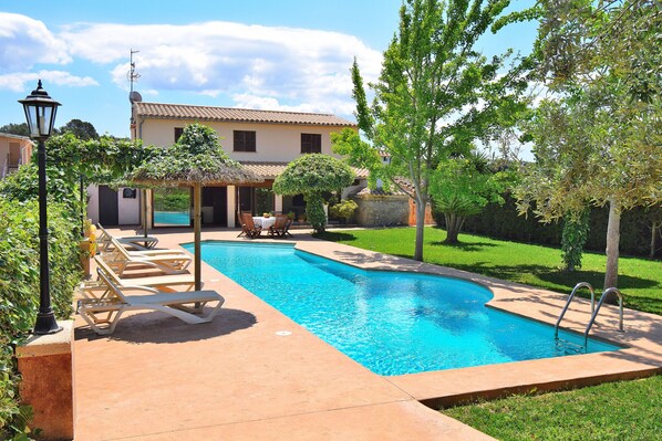 A swimming pool with lounge chairs, a pergola, and a house in the background. - 219 Villa Ca Na Capitana ETV/9534 by Mallorca Char (Ariany)