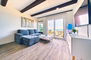 Ein modernes Wohnzimmer mit einer Eckcouch, einem Couchtisch und einer Schiebetür zu einem Balkon.
