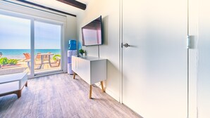 A modern room with a large sliding glass door leading to a balcony with a view of the sea. - Suite 201: Beautiful 3-Bedroom Beachfront Townhouse (Wainfleet)