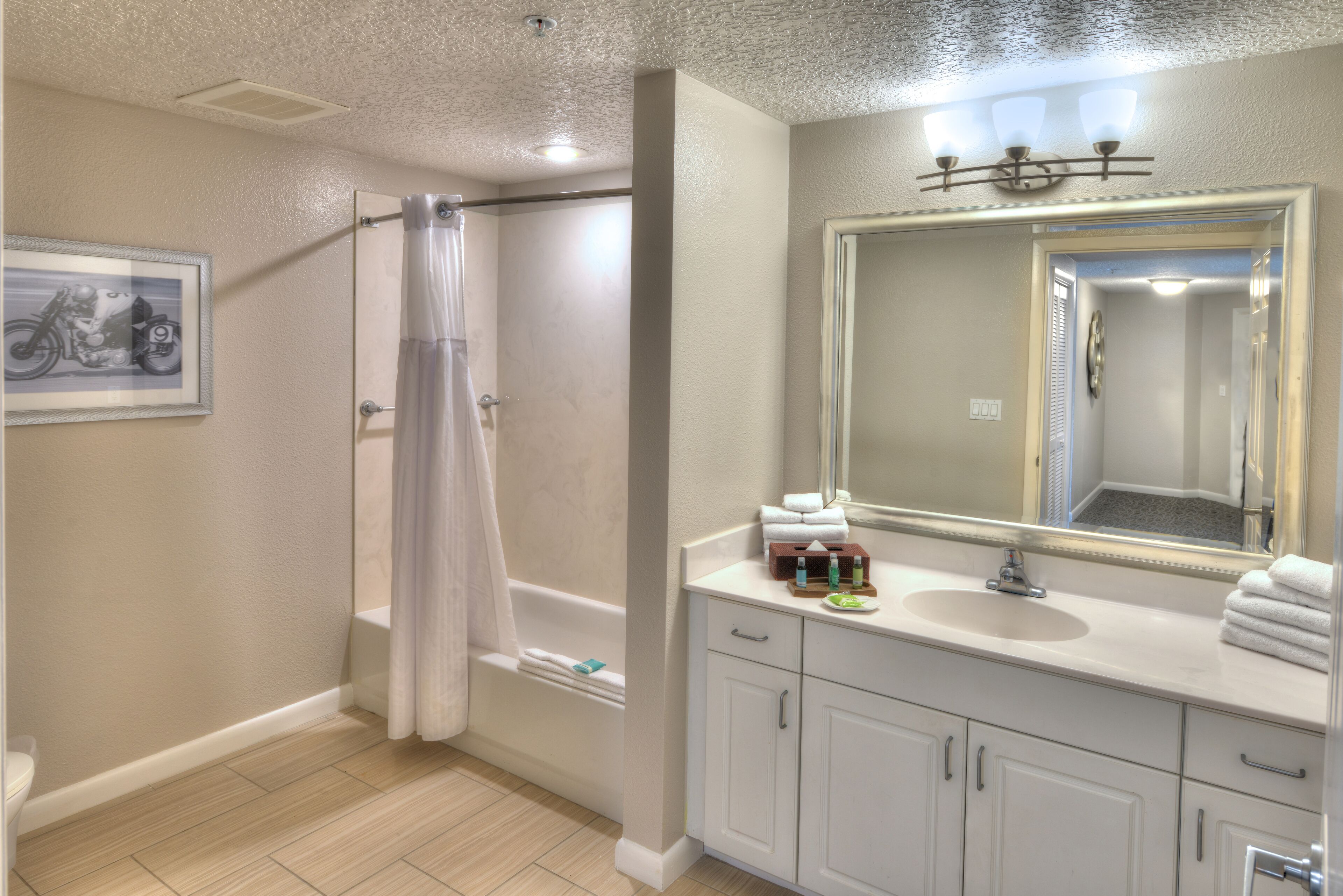 Une salle de bain équipée d’une douche, de toilettes, d’un lavabo et d’un miroir.