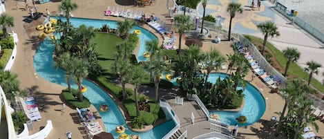 Un resort con varias piscinas, palmeras y tumbonas.
