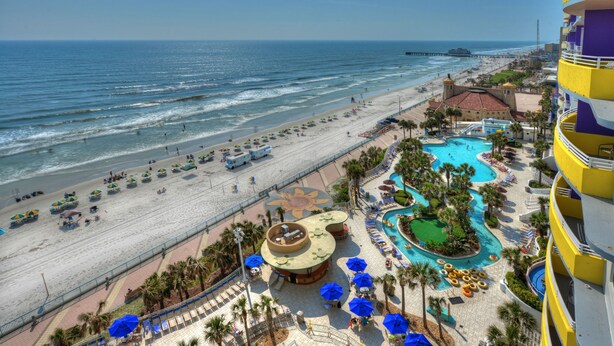 Ein Resort mit Strand, Poolbereich und Meerblick.