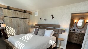 A modern bedroom with a large bed, wooden headboard, and a built-in wardrobe. - Loft on Mountain (in Old Town) (Fort Collins)