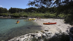 A beach with kayaks and a rocky shoreline. - Villa Dol-Three Bedroom Villa with Pool (Postira)