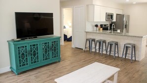 A modern kitchen with white cabinets, a stainless steel refrigerator, and a built-in microwave. - Paradise Vacation Rental with Water Views (Palm Harbor)