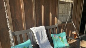 A wooden swing chair with cushions and a glass of iced tea. - 1 Playful Cub-GREAT unbelievable rates, check it out (Cosby)