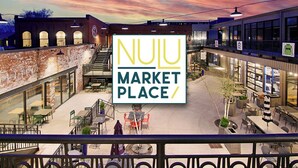 UN MERCADO DE NULU con mesas al aire libre y vistas de los edificios circundantes.
