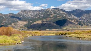 A river with mountains in the background and a clear sky. - Spotted Moon Ranch - River Front - Two Bedroom Cabin (Etna)