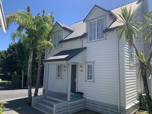 Une maison à deux étages avec un porche à l’avant, un garage et une allée.