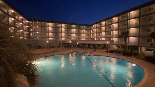 A swimming pool surrounded by a multi-story building with balconies. - Steps away from the BEACH! (Hilton Head Island)