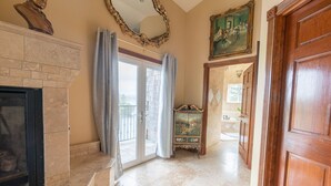 Un hall d’entrée spacieux avec une cheminée, un meuble en bois et un grand miroir.