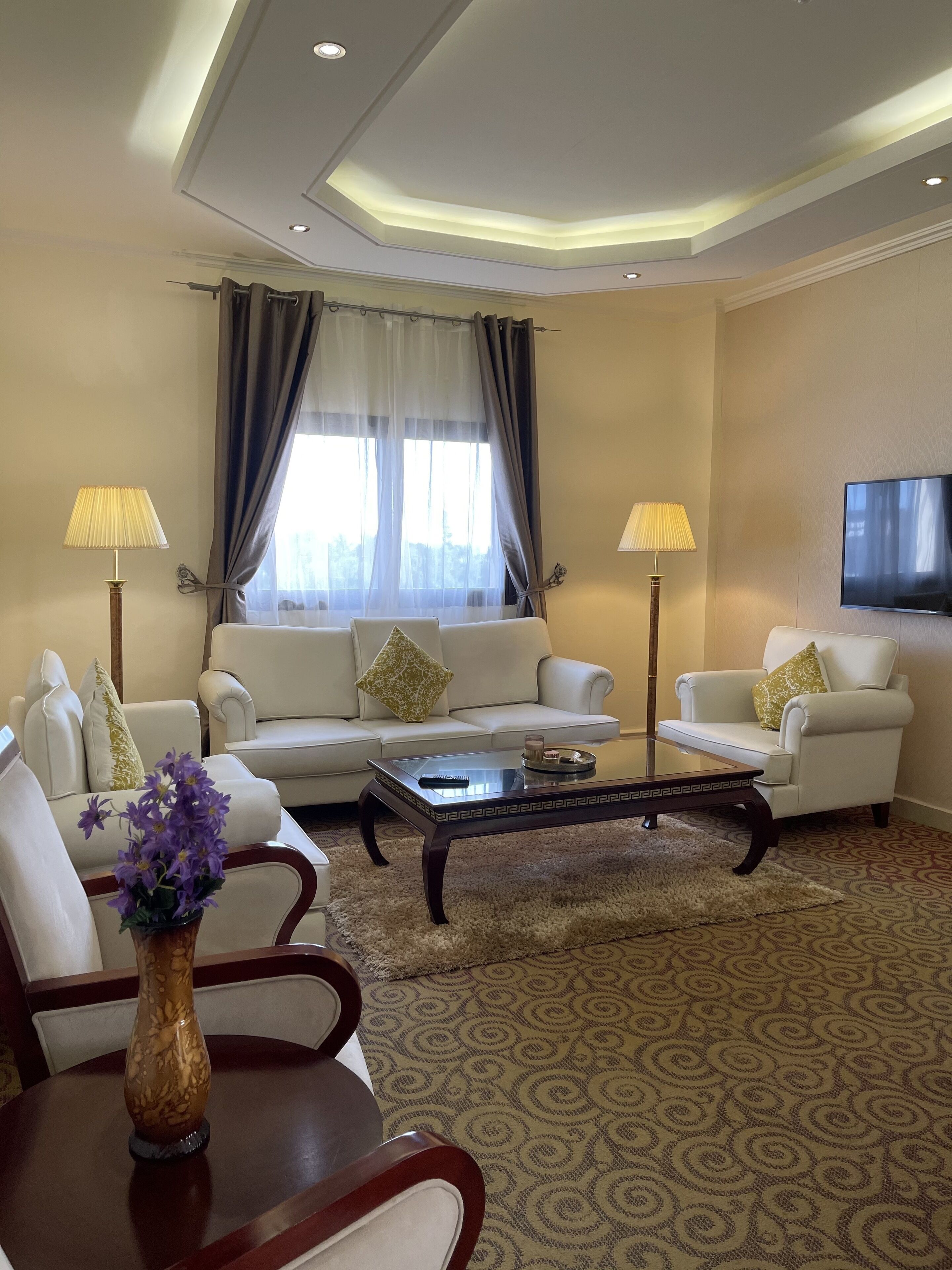 A modern living room with a sofa set, a coffee table, and two lamps.