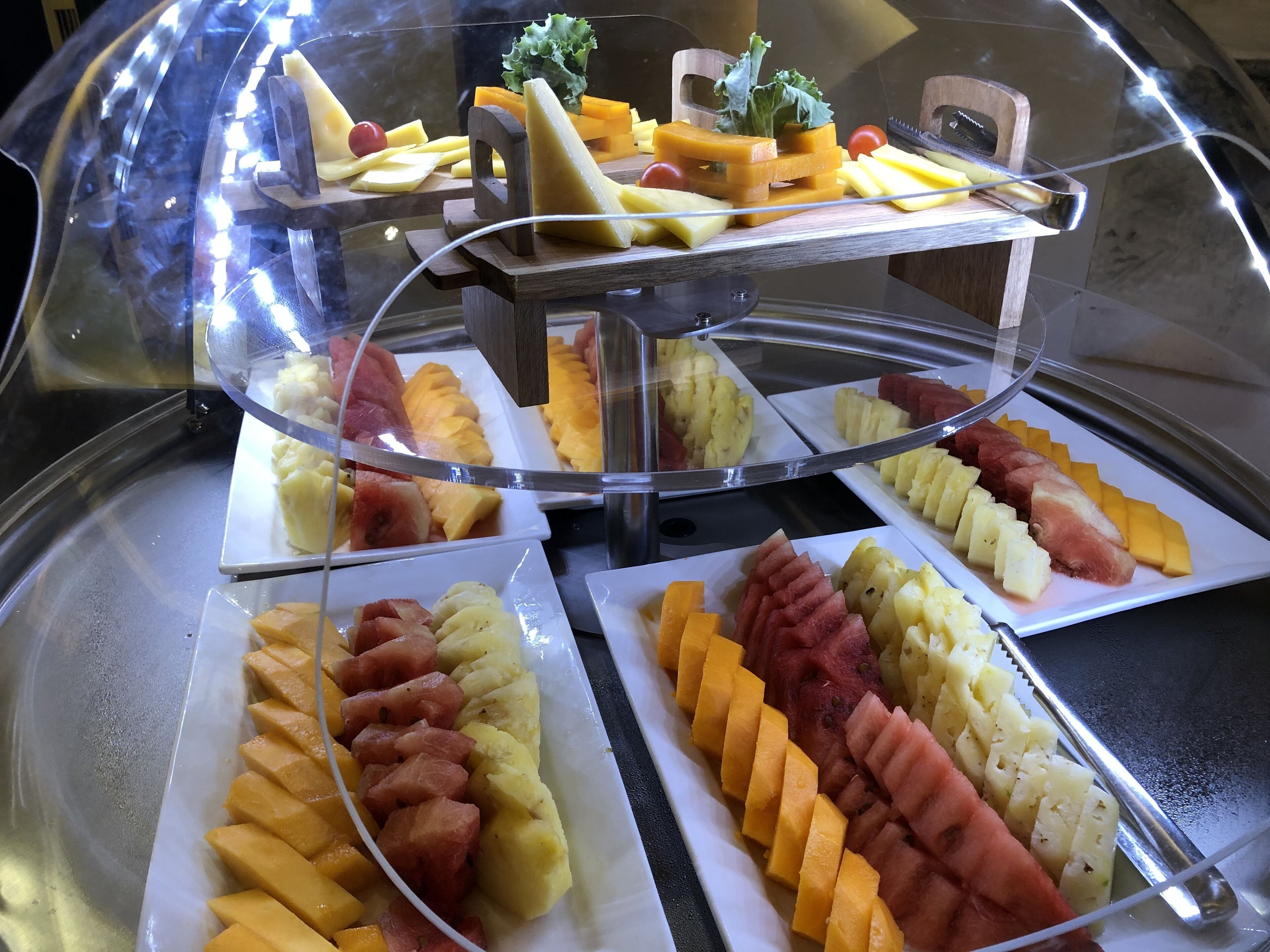 A buffet with various fruits and vegetables neatly arranged on plates.