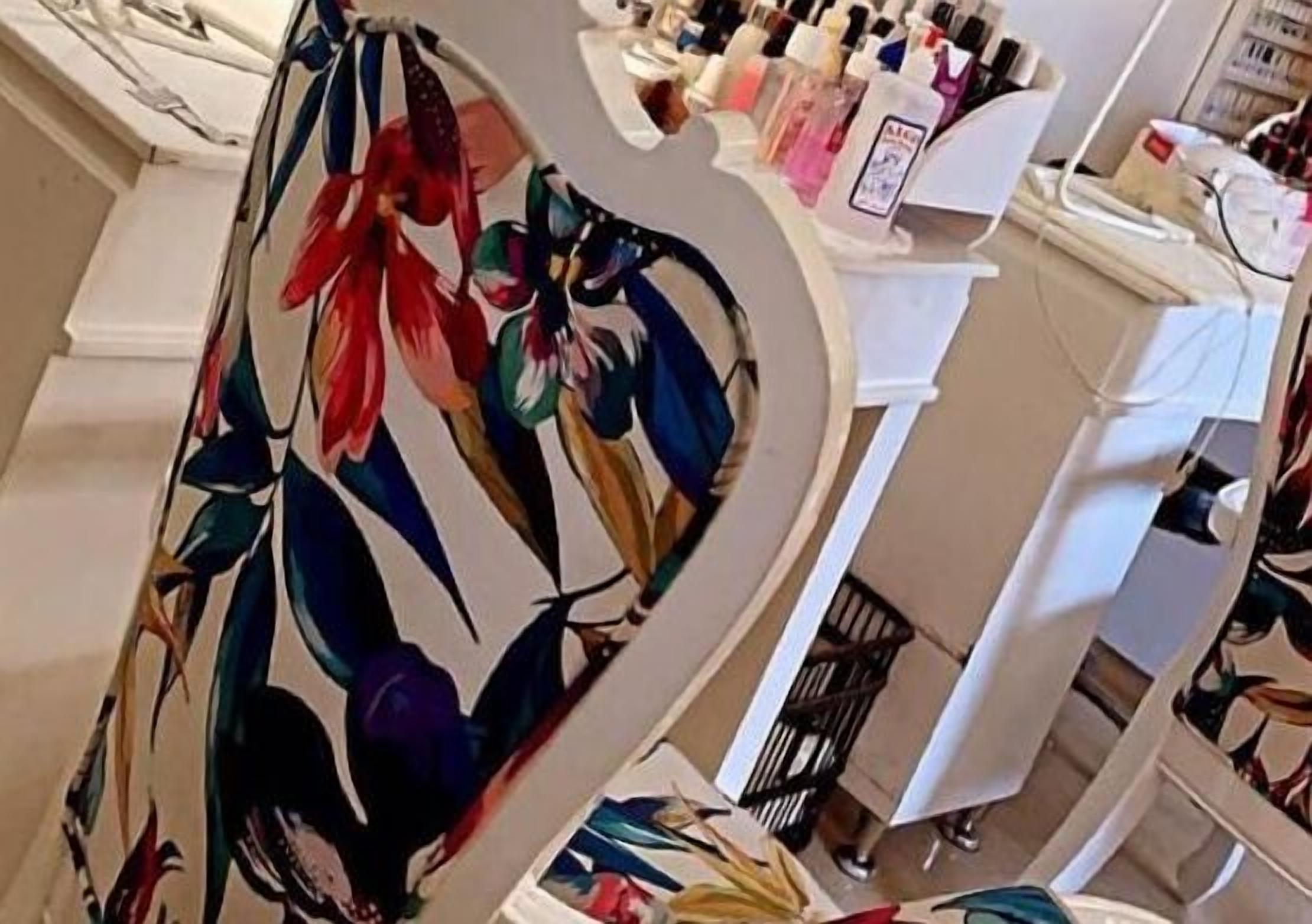 Vestíbulo de hotel con un elemento decorativo central, zona de recepción blanca y varios servicios en estanterías.