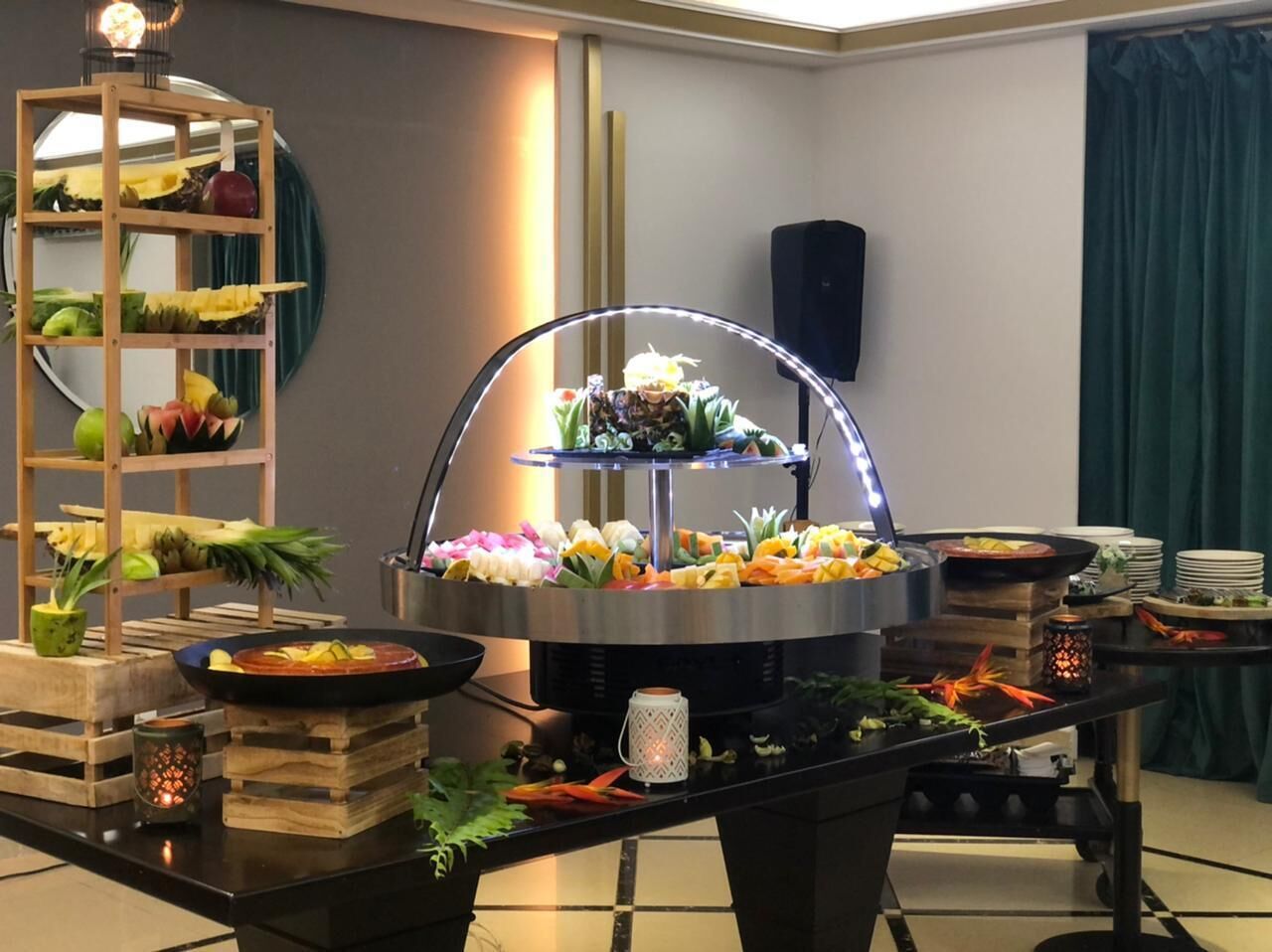 Montaje de bufé con diferentes platillos y elementos decorativos.