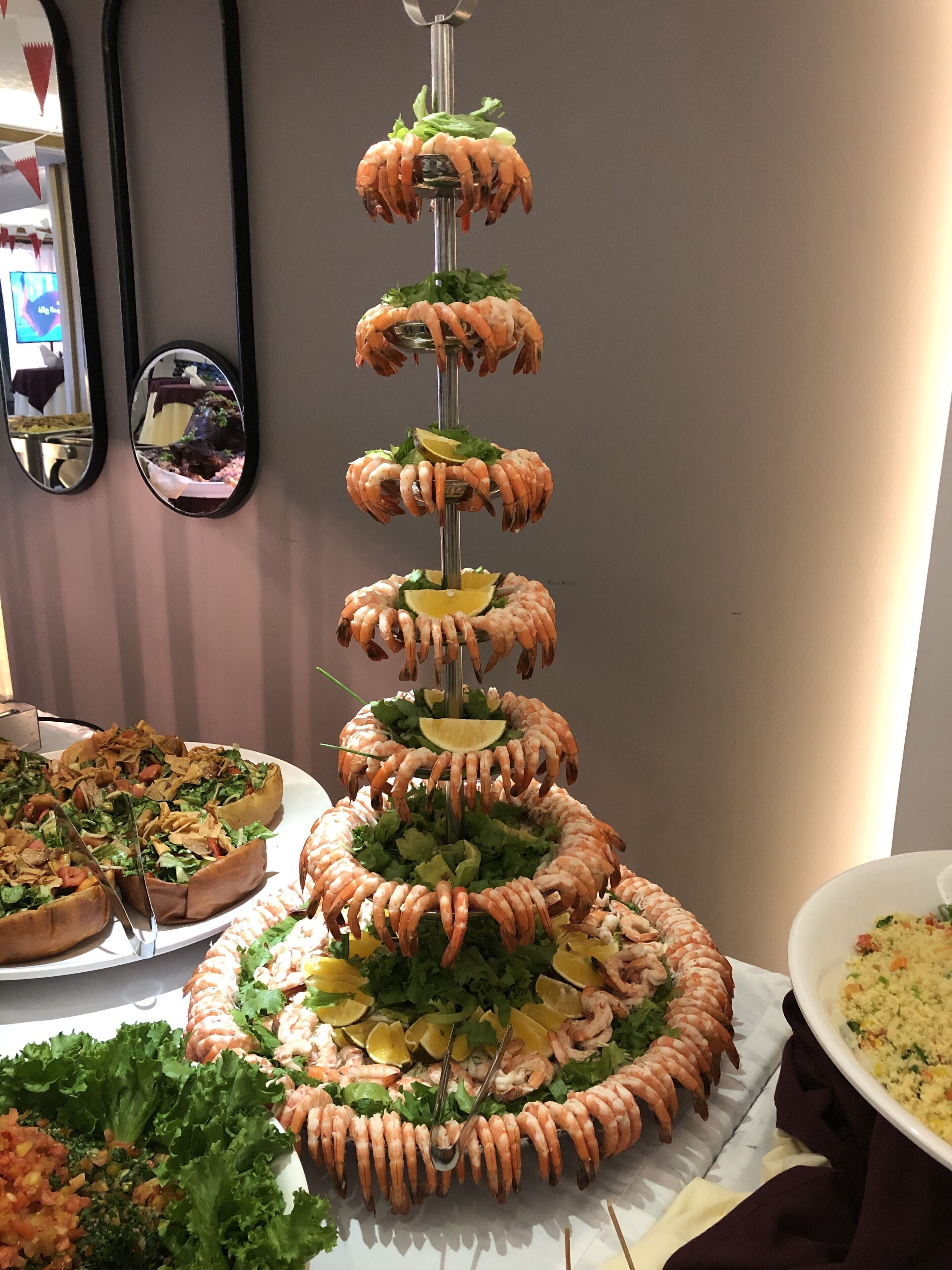 Una torre de camarones en varios niveles, con diferentes guarniciones.