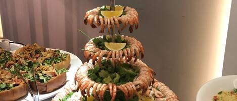 Una torre de camarones en varios niveles, con diferentes guarniciones.