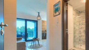 A modern interior with a glass shower, a dining area, and a view of the outdoors. - Wing 77 by Interhome (Pula)