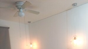 A bedroom with a bed, a ceiling fan, and wall-mounted lights. - 58th Ave. Apartment (Playa del Carmen)