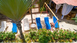 Ein Patio mit Liegestühlen, einer Schaukel und einem kleinen Pool.