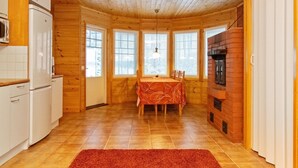 Interior acogedor de una cabaña con cocina, comedor y chimenea.