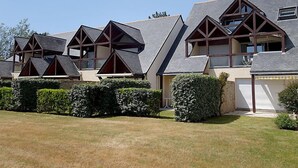 Uma fileira de casas modernas com designs triangulares únicos e estrutura de madeira.