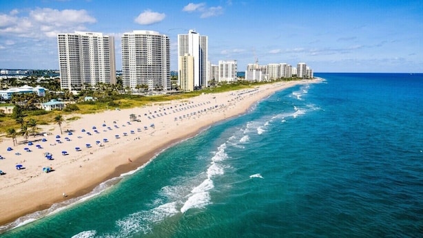 A beach with a row of high-rise buildings in the background.