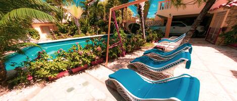 Un espace aménagé au bord de la piscine, avec des chaises longues et une piscine.