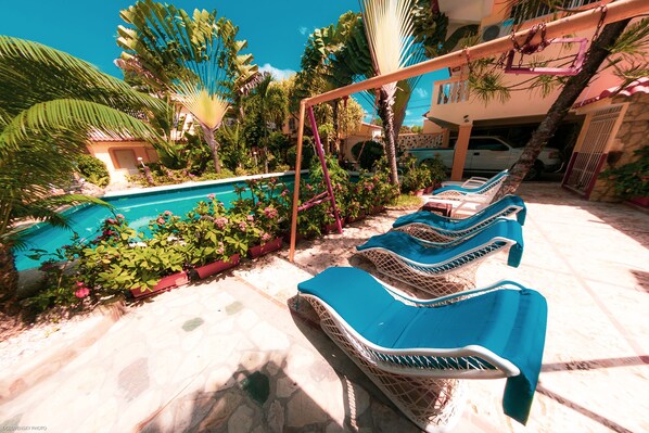 Un espace aménagé au bord de la piscine, avec des chaises longues et une piscine.