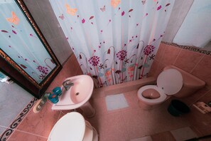 Un baño con inodoro, lavamanos y espejo.