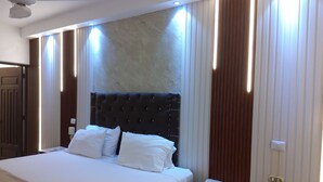 A hotel room with a large bed, a bedside table, a chair, and a ceiling fan. - Deluxe Apartment (7) RESIDENCE TROPICAL GARDEN (Boca Chica)